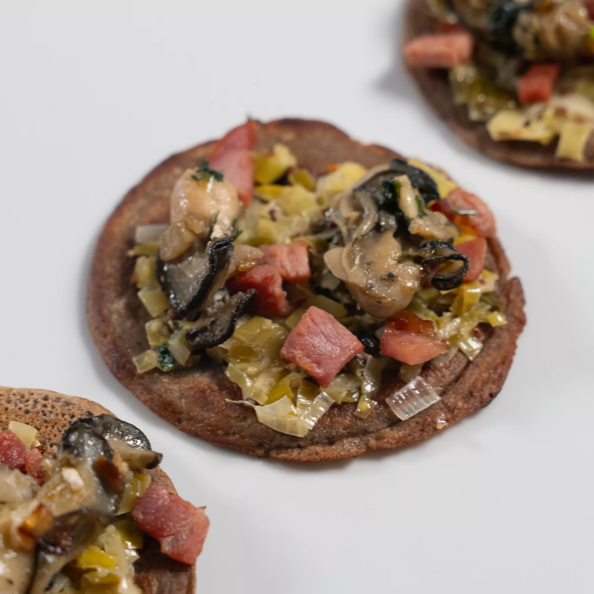 Galette aux huîtres snackées, fondue de poireaux et bacon